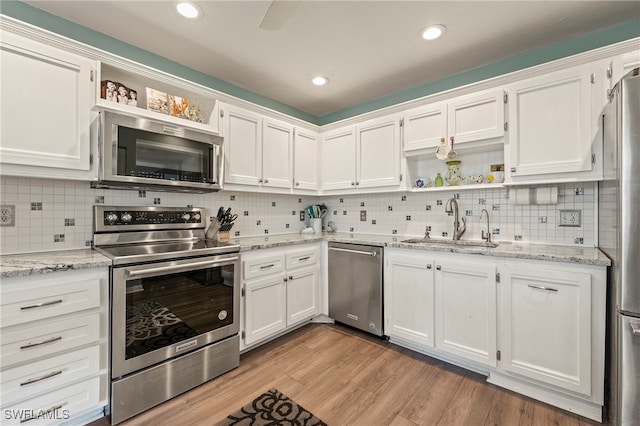 kitchen with appliances with stainless steel finishes, sink, and white cabinetry