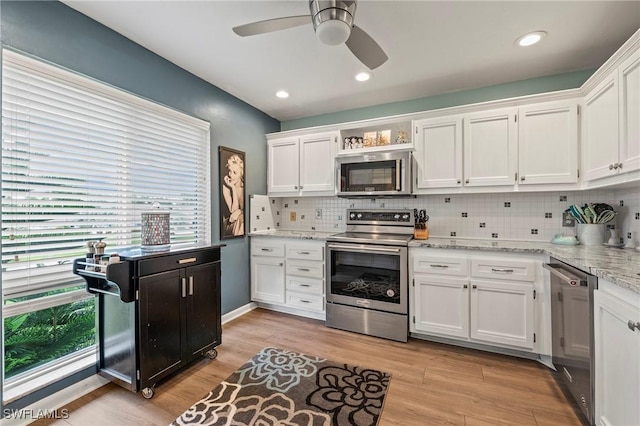 154 Penny Ln Unit 8, Naples, FL 34112 - kitchen with white cabinetry, tasteful backsplash, stainless steel appliances, and light wood finished floors