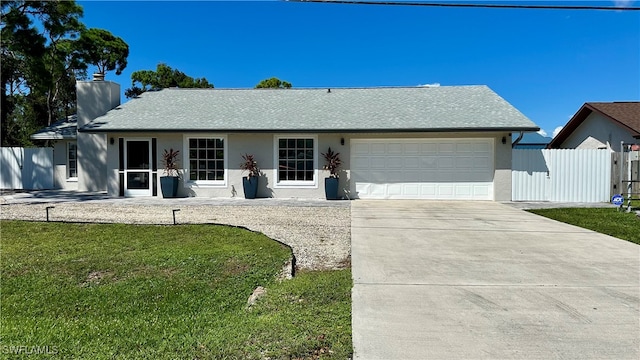 single story home with a garage and a front lawn