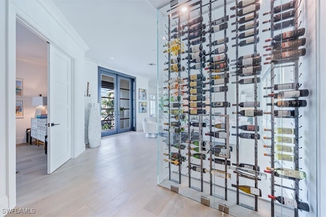 wine room featuring ornamental molding and light wood-style floors