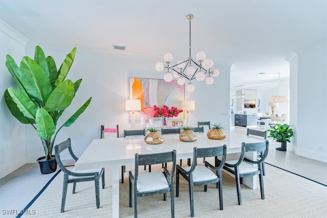 dining space featuring baseboards, an inviting chandelier, visible vents, and crown molding