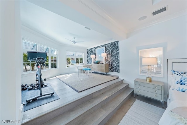 exercise room featuring a ceiling fan, visible vents, crown molding, and wallpapered walls