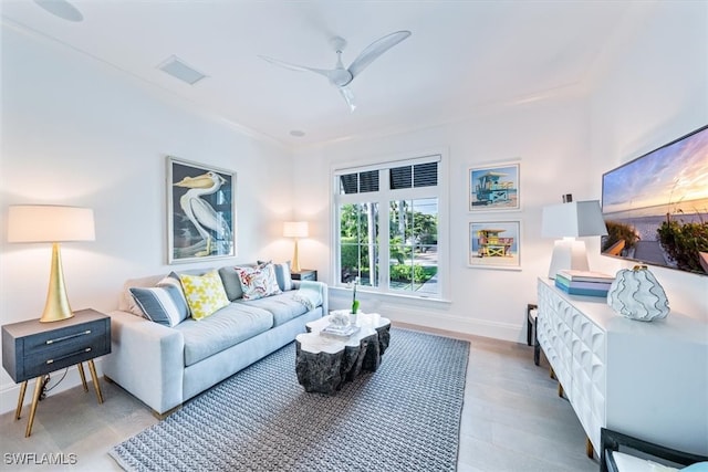 living room with a ceiling fan, visible vents, and baseboards