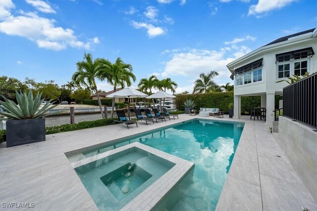 view of pool with an in ground hot tub and a patio