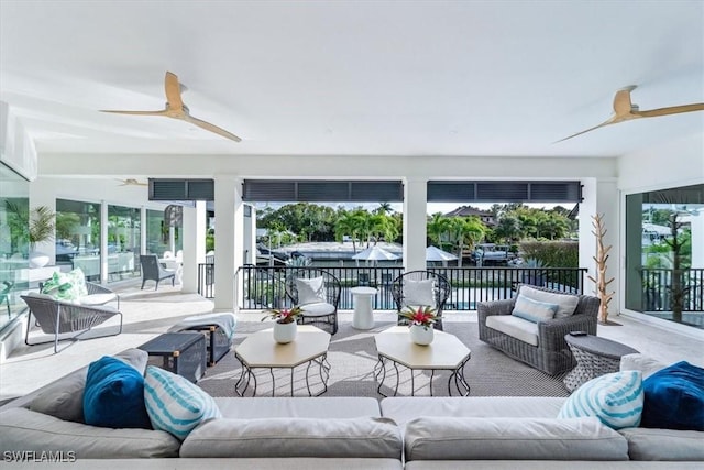 sunroom / solarium featuring a water view and a ceiling fan