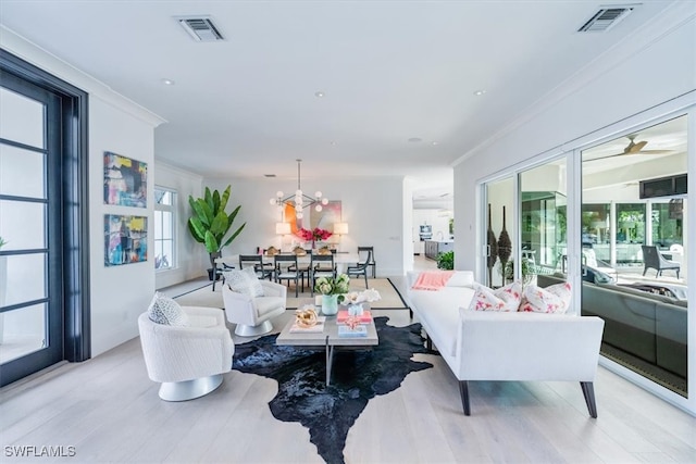 living room with a healthy amount of sunlight, visible vents, and ornamental molding