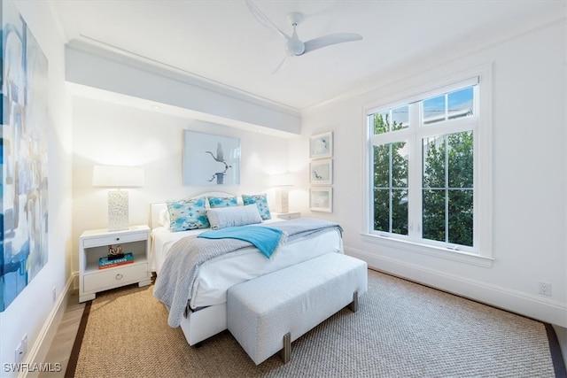 bedroom featuring ceiling fan, crown molding, baseboards, and wood finished floors