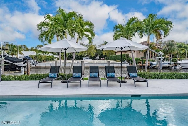 outdoor pool with a patio area and a water view