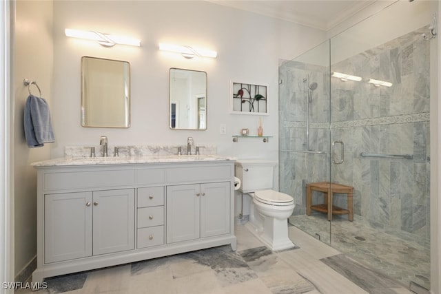 bathroom with vanity, a shower with shower door, toilet, and crown molding