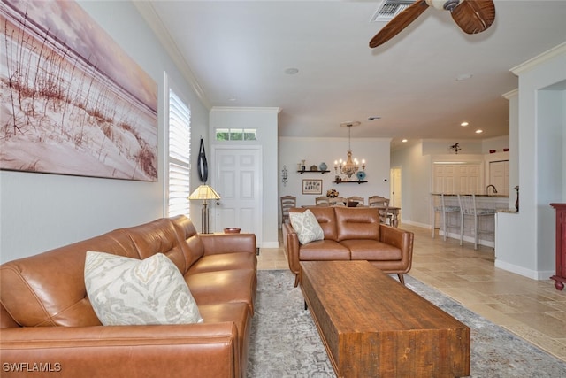 living room with ceiling fan with notable chandelier and crown molding