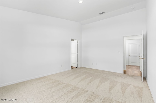 unfurnished room featuring light carpet