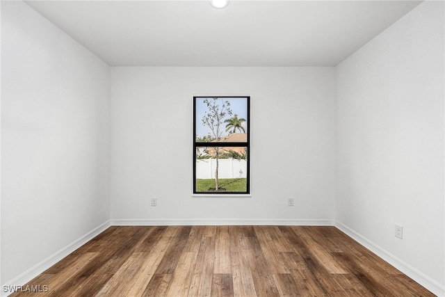 unfurnished room with dark wood-type flooring