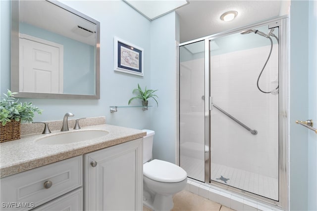 bathroom with toilet, vanity, tile patterned flooring, and a shower with shower door