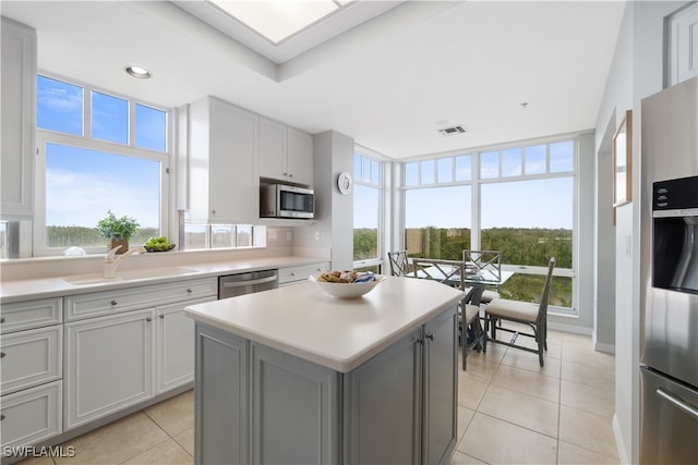 kitchen with a healthy amount of sunlight, sink, appliances with stainless steel finishes, and a center island