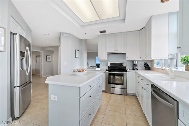 kitchen featuring stainless steel appliances, light tile patterned floors, sink, and white cabinetry