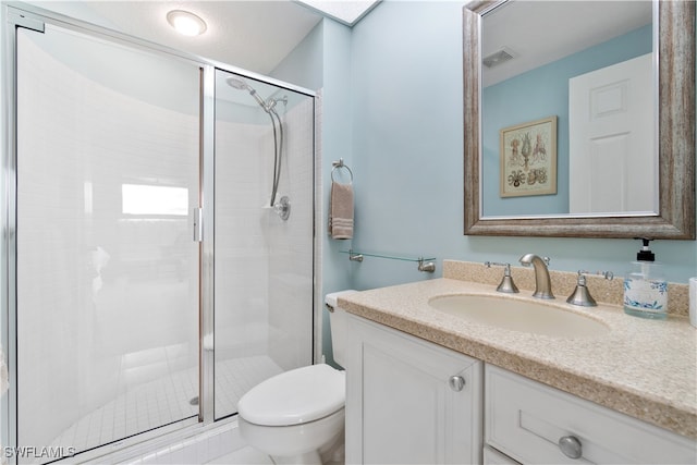 bathroom with vanity, toilet, and a shower with shower door