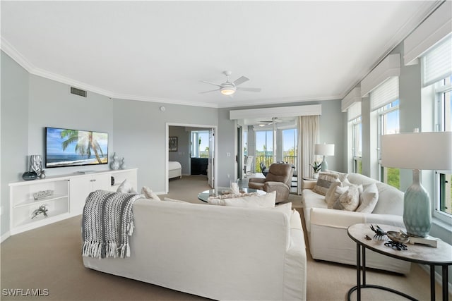 living room with ornamental molding, carpet, and ceiling fan