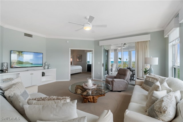 carpeted living room featuring ceiling fan, a healthy amount of sunlight, and ornamental molding