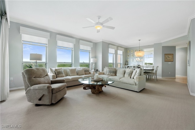 living room featuring ornamental molding, ceiling fan with notable chandelier, light carpet, and a healthy amount of sunlight