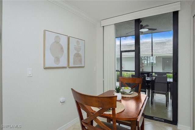 tiled dining area with ceiling fan, expansive windows, and ornamental molding