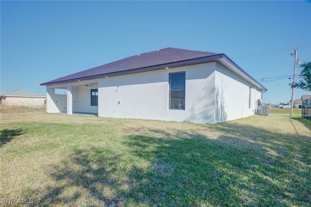 back of house with a yard and central AC unit