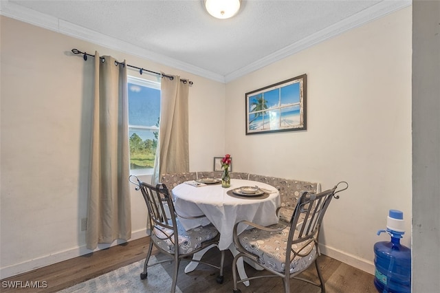 dining space with a textured ceiling, dark hardwood / wood-style floors, and ornamental molding