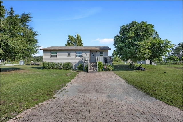 single story home featuring a front lawn