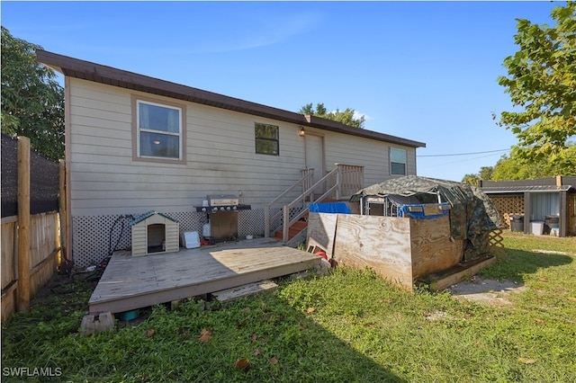 back of house featuring a lawn and a deck