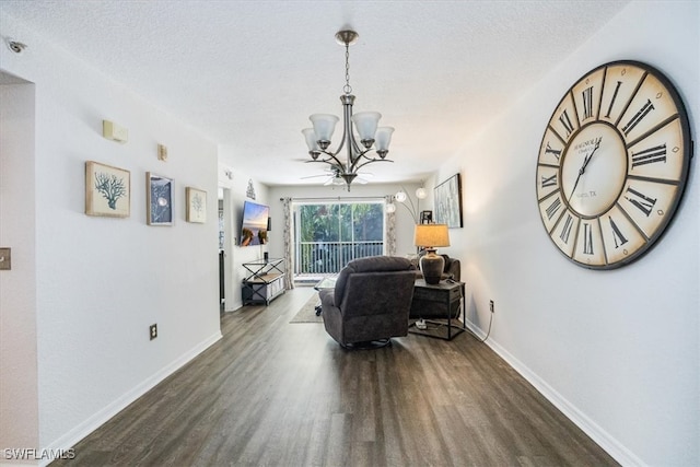 living room with a textured ceiling, a chandelier, and dark hardwood / wood-style floors