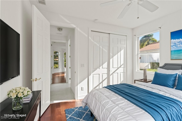 bedroom featuring ceiling fan, dark wood-type flooring, and a closet