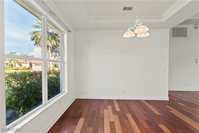 empty room with dark hardwood / wood-style floors, crown molding, a notable chandelier, and a tray ceiling