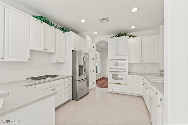 kitchen featuring light tile patterned flooring, appliances with stainless steel finishes, sink, and white cabinetry