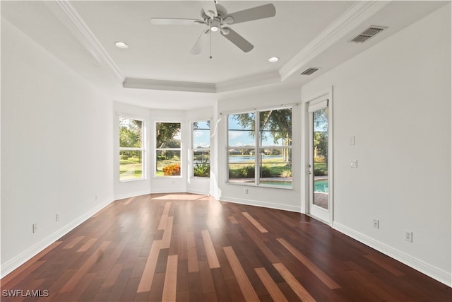 spare room with dark wood-type flooring, ornamental molding, and a healthy amount of sunlight