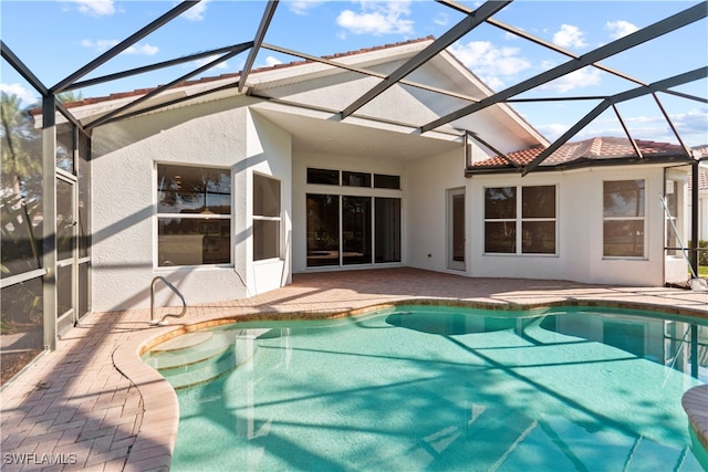 view of swimming pool with glass enclosure and a patio area