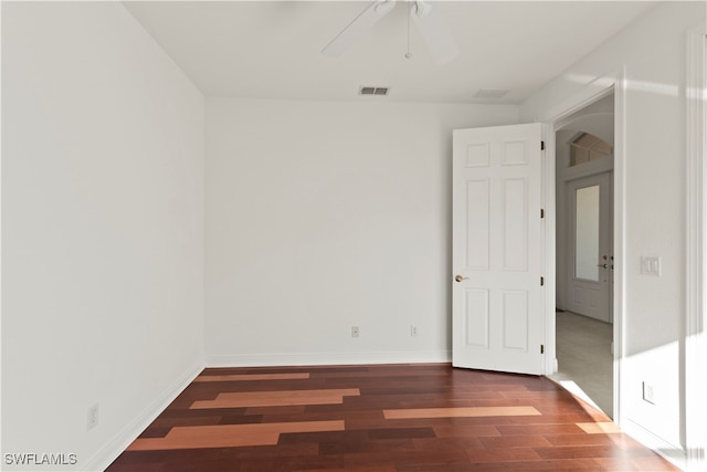 empty room with ceiling fan and dark hardwood / wood-style flooring