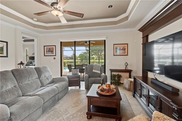 living room featuring crown molding, a tray ceiling, ceiling fan, and light tile patterned flooring