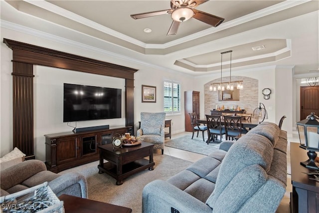 living room with ornamental molding, ceiling fan, and a tray ceiling