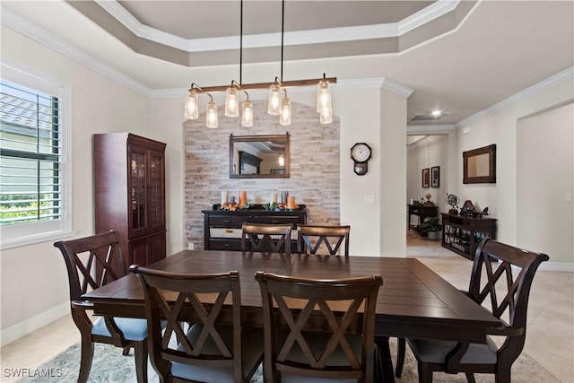 dining room featuring light tile patterned floors, ornamental molding, and a raised ceiling