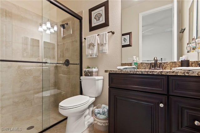 bathroom with vanity, toilet, an enclosed shower, and tile patterned flooring