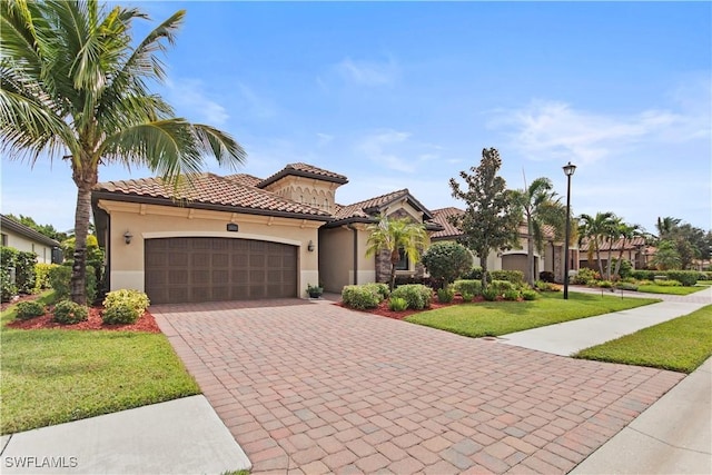 mediterranean / spanish-style home with a garage and a front lawn