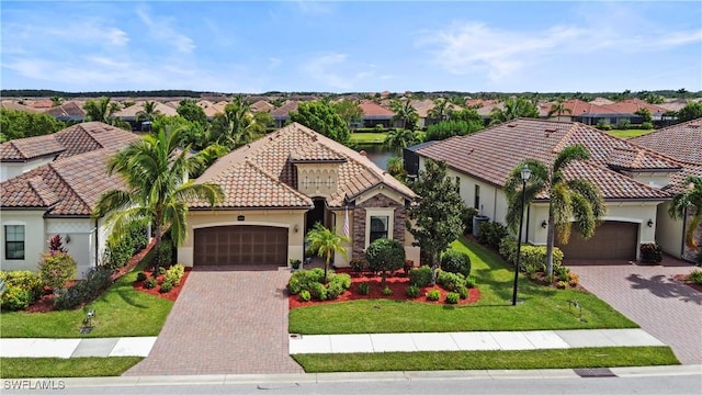 mediterranean / spanish house featuring a garage and a front lawn