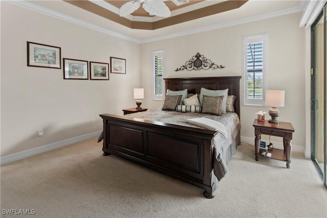 carpeted bedroom with crown molding, ceiling fan, and a tray ceiling