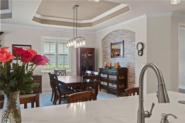 dining area with crown molding and a raised ceiling