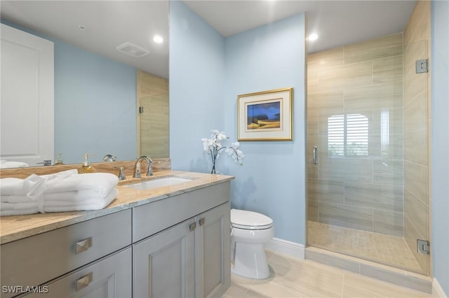 bathroom featuring tile patterned flooring, vanity, a shower with shower door, and toilet