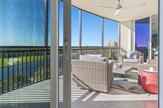 sunroom with a water view and ceiling fan