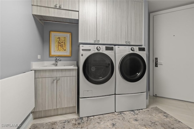 washroom featuring cabinets, sink, and separate washer and dryer