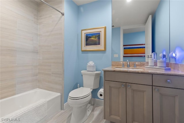 full bathroom featuring tiled shower / bath, vanity, and toilet