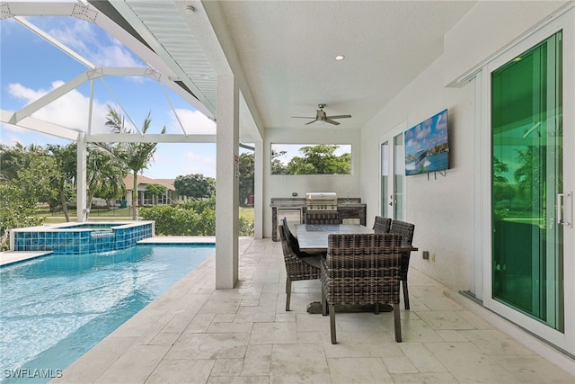 view of swimming pool featuring ceiling fan, grilling area, a patio area, a lanai, and exterior kitchen