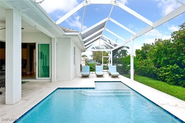 view of pool with a patio and glass enclosure