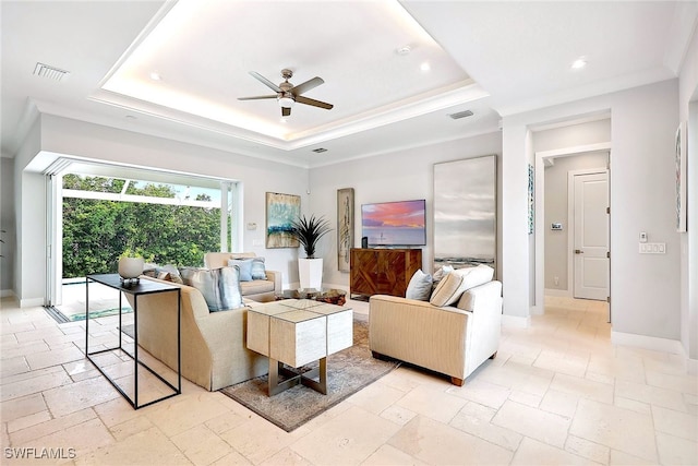 living room with a tray ceiling and ceiling fan